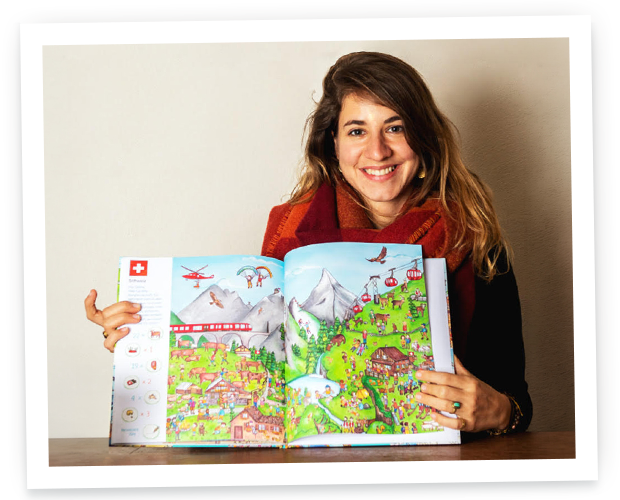 A smiling woman with long hair holds open a personalized children's book titled My Search-and-Find World Trip, showing a colorful illustrated Swiss mountain scene with a train and a cable car.